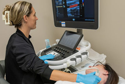 Ultrasound technician performing a Carotid scan